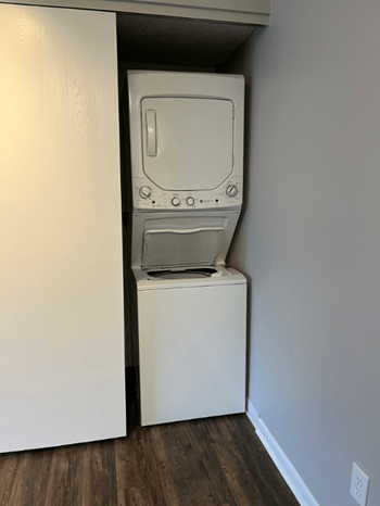 A white dryer is in a small closet.