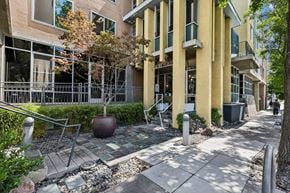 Palo Alto apartment for rent - A tree in a pot sits in front of a building with a yellow and white facade.