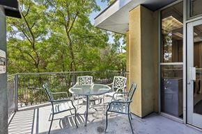 Palo Alto apartment for rent - A patio with a table and chairs is surrounded by a metal fence.