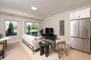 Roseville apartment for rent - A modern living room with a white sofa and a black television.