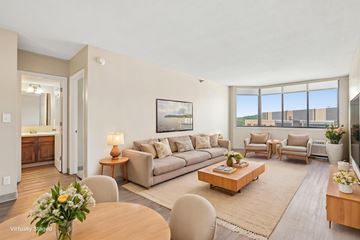 St. Paul apartment for rent - A living room with a brown sofa, a wooden coffee table, and a painting on the wall.