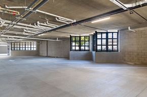 Chula Vista apartment for rent - A large, empty industrial space with concrete floors and exposed ceiling pipes.