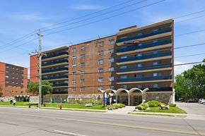 Hamilton apartment for rent - A large brick building with a parking garage on the top floor.