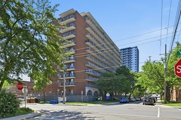 Hamilton apartment for rent - A tall apartment building with a stop sign in front of it.