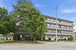 Hamilton apartment for rent - A large apartment building with a tree in front of it.