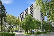 Hamilton apartment for rent - A large grey building with a blue sign in front of it.