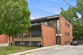 Hamilton apartment for rent - A black car is parked in front of a brick building with the number 70 on it.