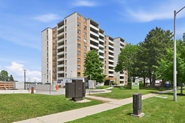 Hamilton apartment for rent - A tall apartment building with a grassy area in front of it.