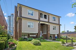 Kitchener apartment for rent - A two-story house with a well-maintained lawn and a small garden in front.