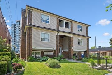 Kitchener apartment for rent - A two-story house with a well-maintained lawn and a small garden in front.