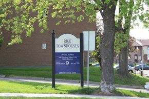 Hamilton apartment for rent - A sign for Rice Townhouses stands in front of a brick building.
