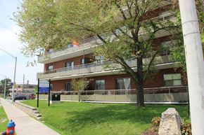 Hamilton apartment for rent - A red brick building with a blue sign in front of it.