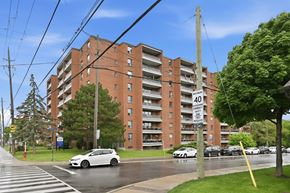 Stoney Creek apartment for rent - A street view of a residential building with cars parked on the side of the road.