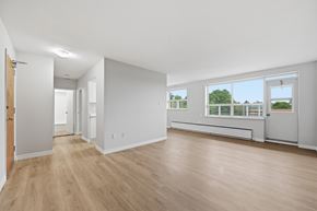 Hamilton apartment for rent - A spacious room with wooden floors and white walls.