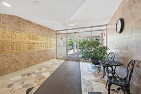 Hamilton apartment for rent - A hallway with a tiled floor and a wall of mailboxes.