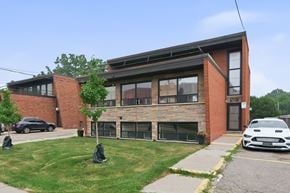 Hamilton apartment for rent - A white car is parked in front of a brick building.