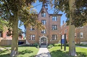 Kitchener apartment for rent - A large brick building with a gate in front.