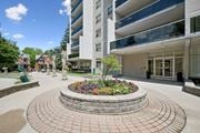 Kitchener apartment for rent - A large building with a circular flower bed in front.
