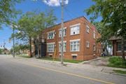 Kitchener apartment for rent - A red brick building with a black gate in front.
