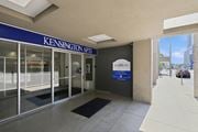 Hamilton apartment for rent - The image shows the entrance to Kensington Apartments with a blue signboard and a glass door.