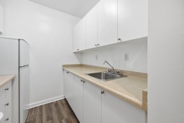 Hamilton apartment for rent - A kitchen with white cabinets and a beige countertop.
