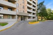 Hamilton apartment for rent - A large building with a parking lot in front.