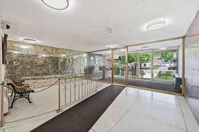 Stoney Creek apartment for rent - A hallway with a bench and a glass door leading outside.