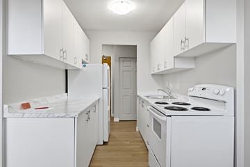 Hamilton apartment for rent - A white kitchen with a stove, oven, and refrigerator.