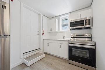 Kitchener apartment for rent - A kitchen with white cabinets and a stainless steel refrigerator.