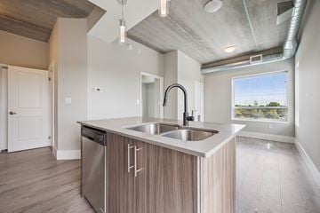 Kitchener apartment for rent - A modern kitchen with a stainless steel sink and wooden cabinets.