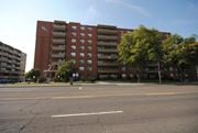 Hamilton apartment for rent - A large red brick building with a parking lot in front.