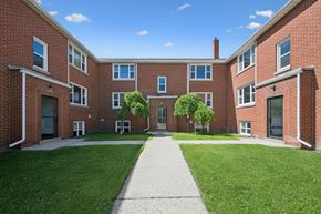 Kitchener apartment for rent - A red brick building with a walkway in front.
