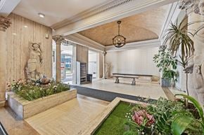 Hamilton apartment for rent - A room with a statue, a bench, and a planter with flowers.