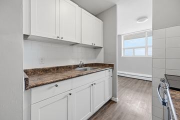 Hamilton apartment for rent - A kitchen with white cabinets and a granite countertop.