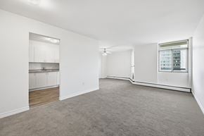 Hamilton apartment for rent - A spacious, empty room with a window and a built-in cabinet.