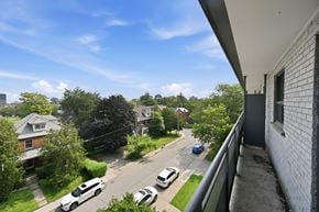 Hamilton apartment for rent - A view from a balcony overlooking a street with cars and houses.