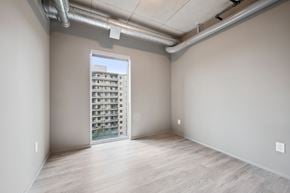 Kitchener apartment for rent - A room with a view of a building outside through a window.
