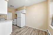 Stoney Creek apartment for rent - A kitchen with white appliances and wooden floors.