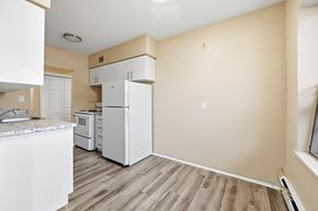 Stoney Creek apartment for rent - A kitchen with white appliances and wooden floors.