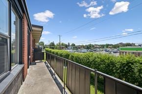 Kitchener apartment for rent - A balcony with a railing overlooks a parking lot.