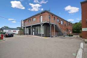 Kitchener apartment for rent - A building with a parking lot in front of it.