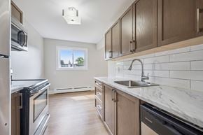 Waterloo apartment for rent - A kitchen with a stainless steel refrigerator, a stainless steel oven, and a marble countertop.