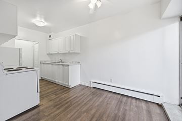 Hamilton apartment for rent - A kitchen with white cabinets and a white stove top oven.