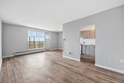 Hamilton apartment for rent - A spacious room with wooden flooring and a large window.