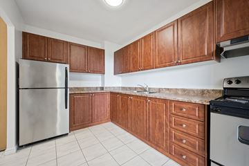 Kitchener apartment for rent - A kitchen with wooden cabinets and a stainless steel refrigerator.