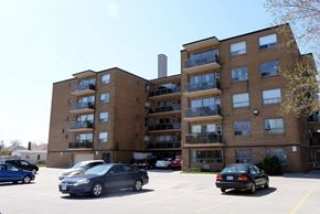 Hamilton apartment for rent - A parking lot with cars and apartment buildings.