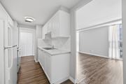 Hamilton apartment for rent - A kitchen with white cabinets and a white fridge.