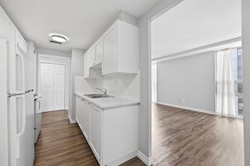 Hamilton apartment for rent - A kitchen with white cabinets and a white fridge.