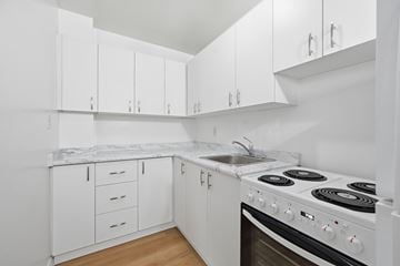Hamilton apartment for rent - A white kitchen with a stove and cabinets.