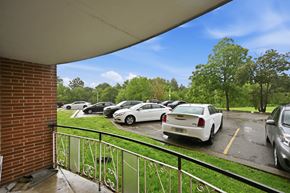 Stoney Creek apartment for rent - A parking lot with cars and trees in the background.